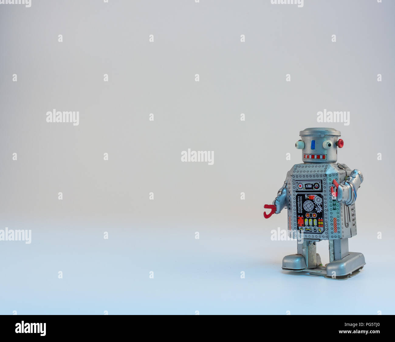Tin clockwork robot with faded white background Stock Photo