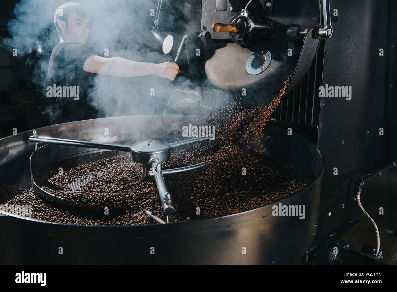 Coffee Loading Machine Mexico Professional male roaster loading machine with coffee beans Stock Photo ...