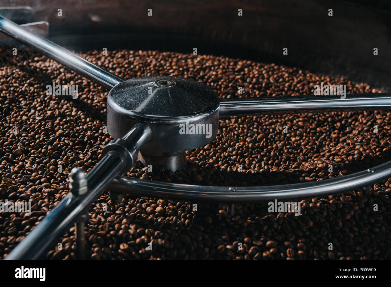 Aromatic coffee beans being roasted in professional machine Stock Photo