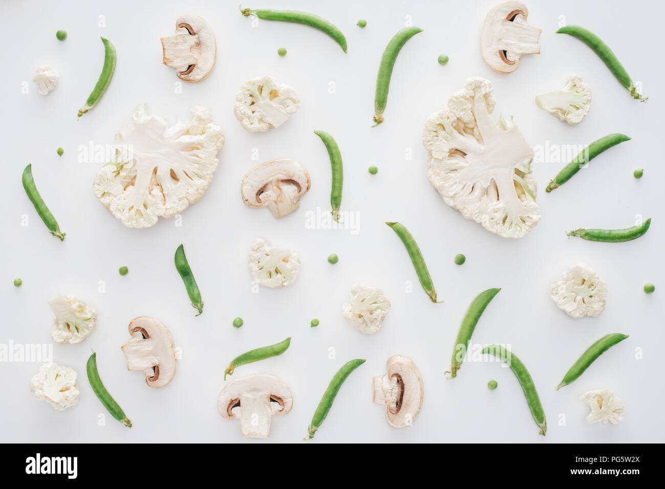 top view of fresh sliced cauliflower, mushrooms and green peas isolated on white background Stock Photo