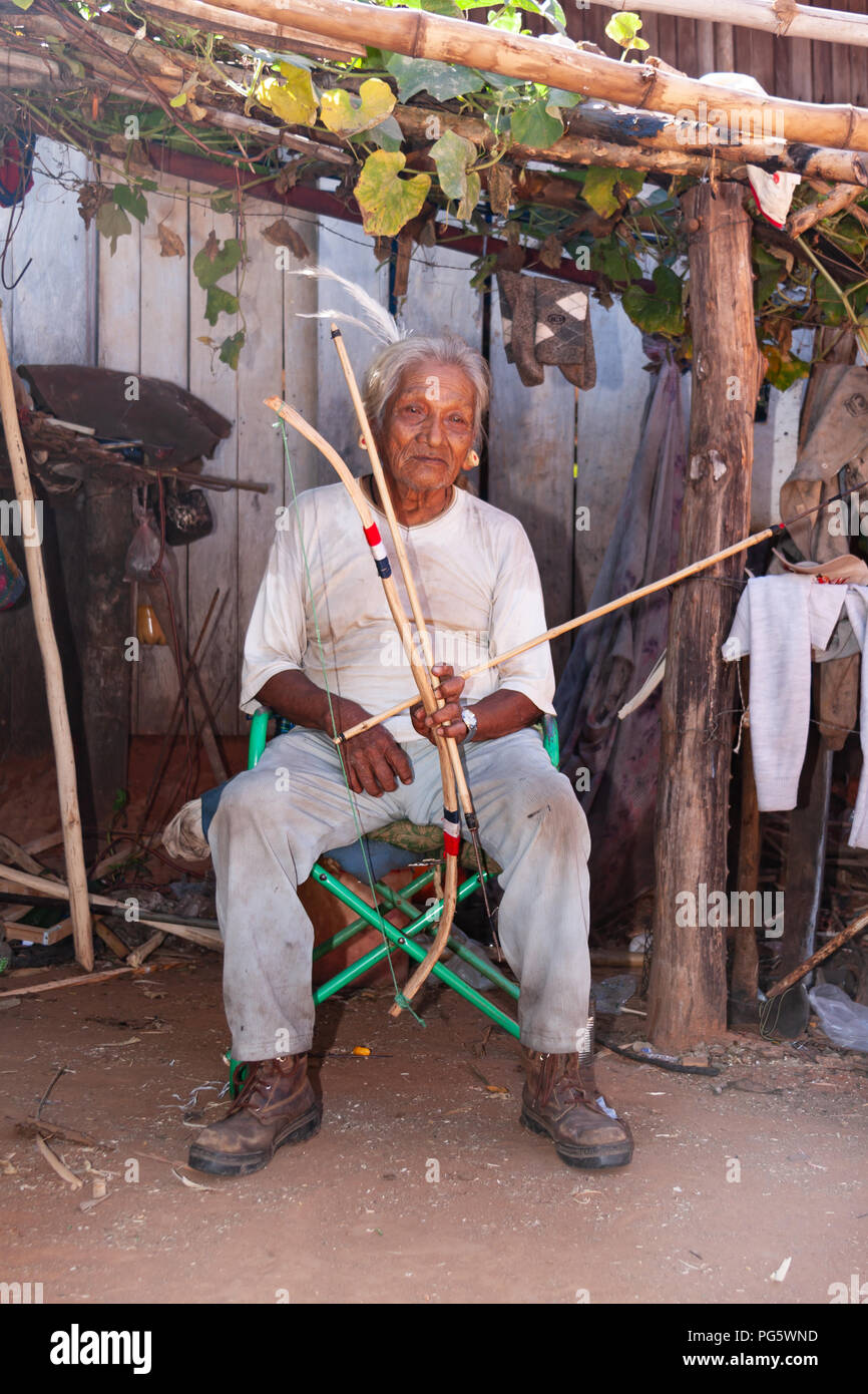 Portrait of Maka indian elderly man with arrow and bow, at the village on the outskirts of Asuncion, Paraguay Stock Photo