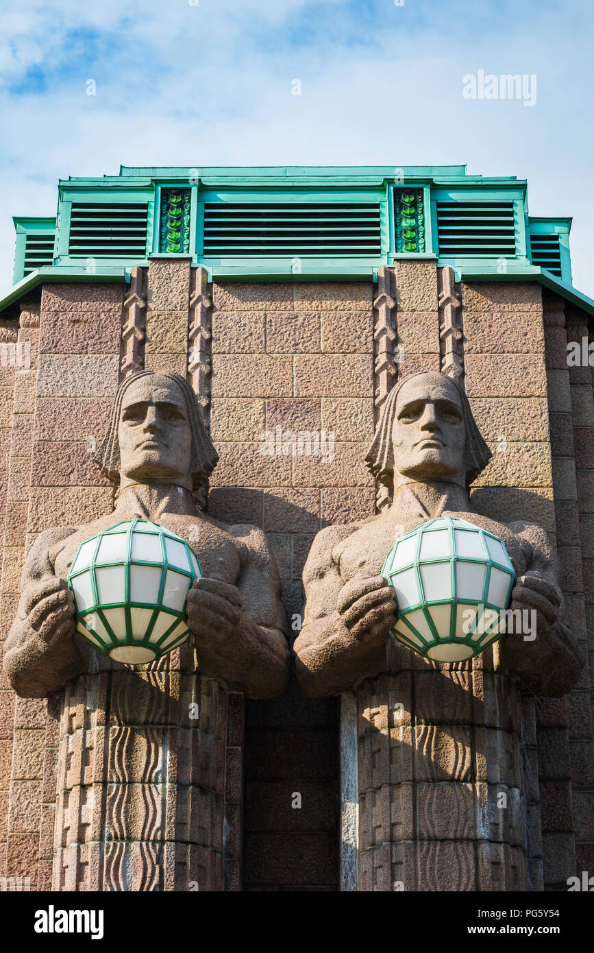 Helsinki Central Railway Station, view of two huge granite statues holding globe lights sited at the entrance to Helsinki Central Station, Finland. Stock Photo