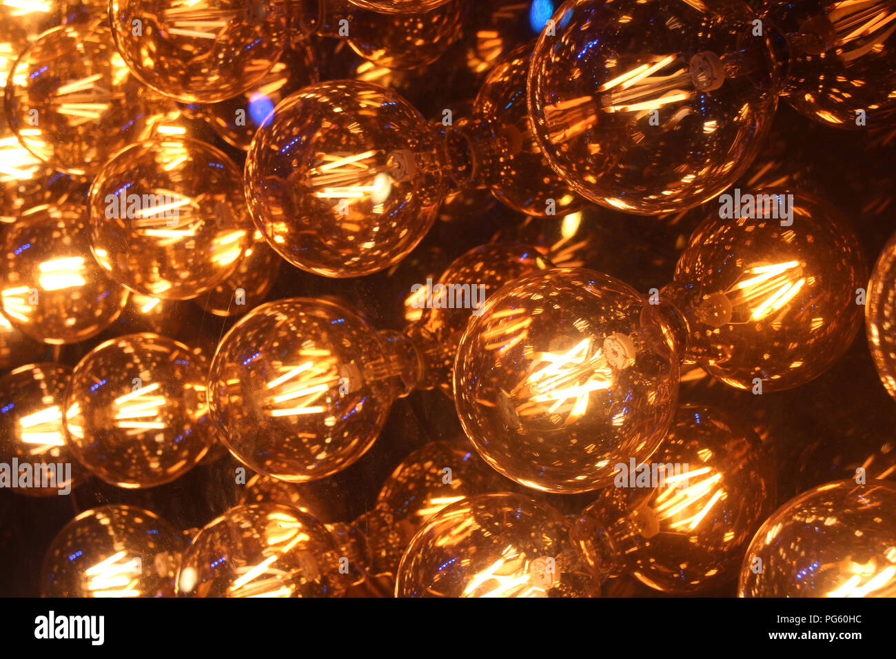 Many amber yellow warm color incandescent light bulbs, tungsten light bulbs, light up as a inspiring pattern background Stock Photo