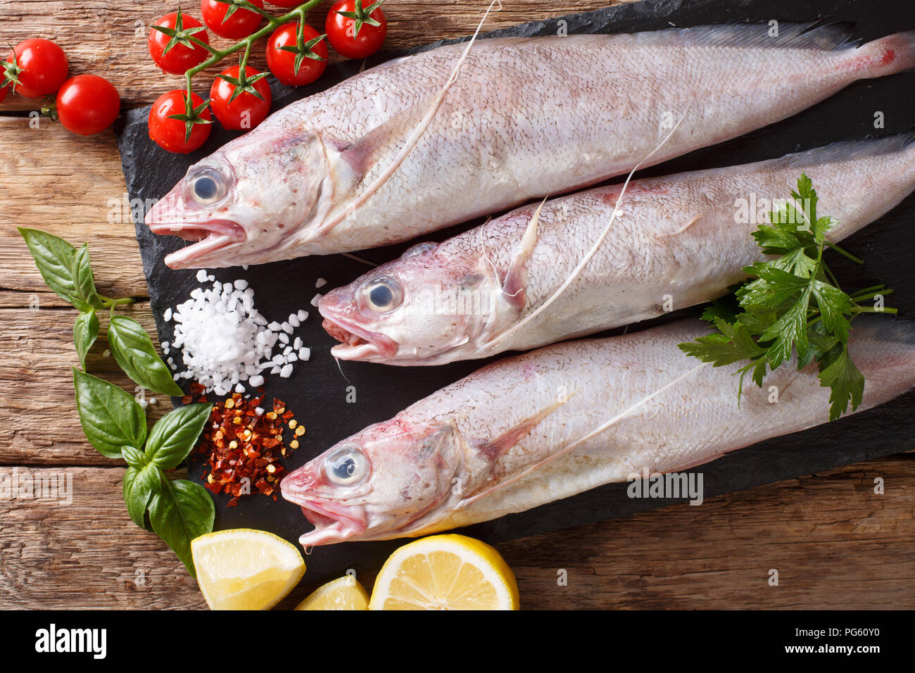 Raw Forkbeard or mostella fish with ingredients close-up on the table. Horizontal top view from above Stock Photo
