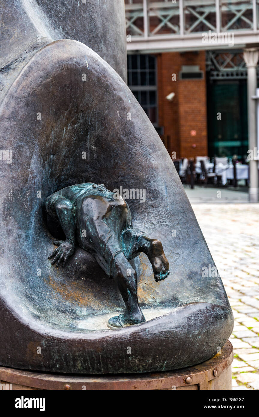 A detail of an outside metal art work showing a man crawling into a hole at the Stary Browar shopping centre in Poznań (Poznan), Poland Stock Photo