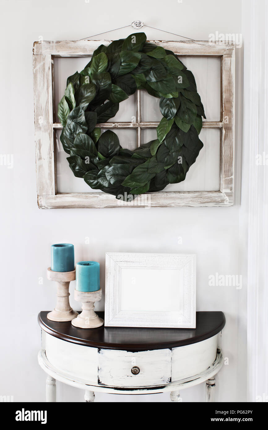 Blank photo frame sitting on a rustic half moon table table below an