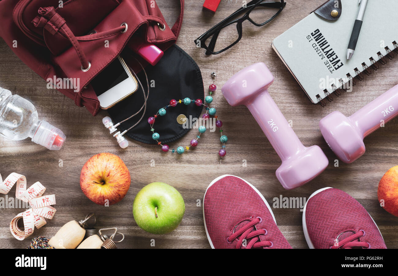 Woman active healthy lifestyle concept. Creative flat lay of sport and fitness equipments  with woman accessories, apples, bottle of waters, sports sh Stock Photo