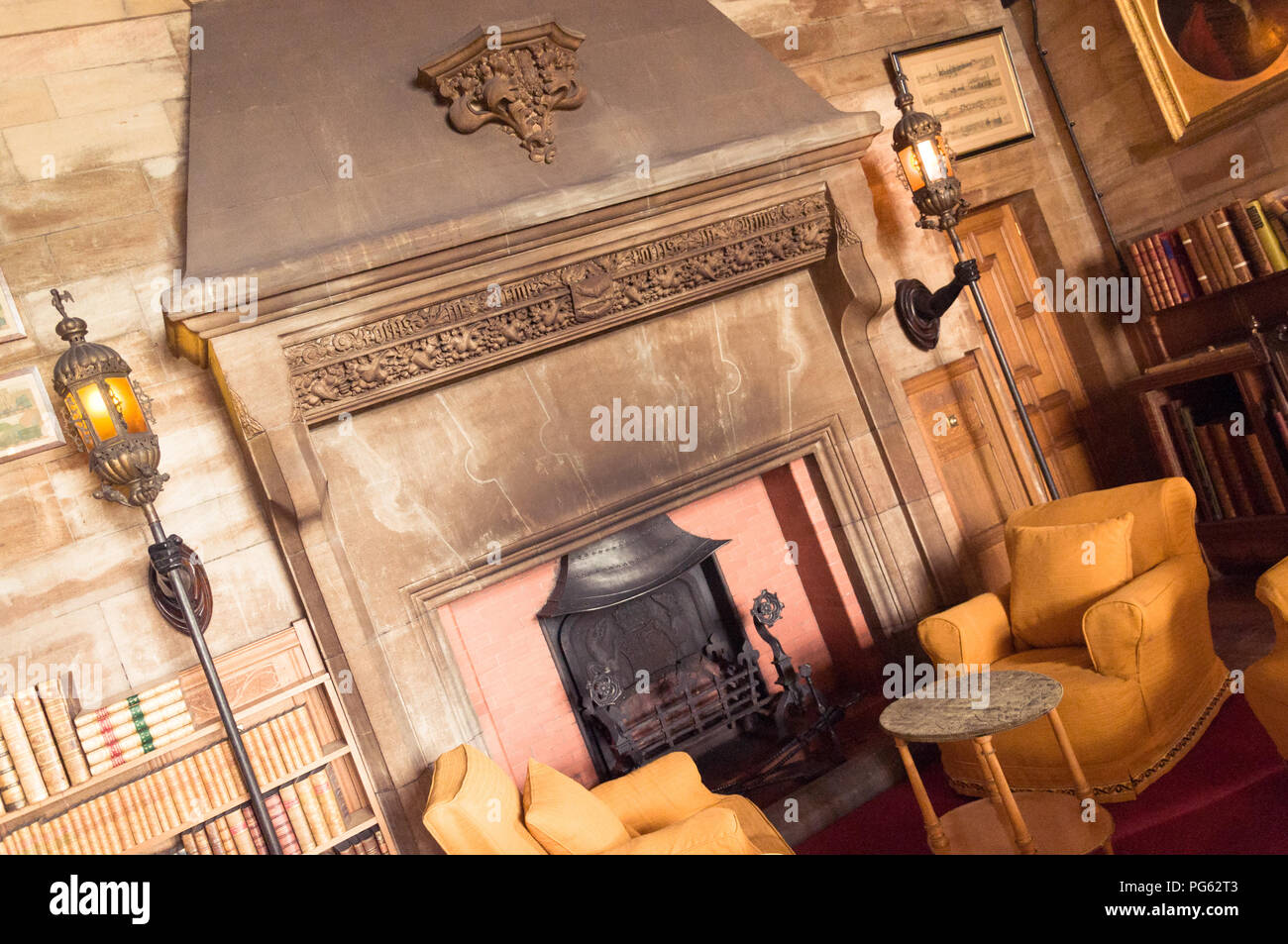 A great fireplace and some chairs in Bamburgh Castle, Northumberland, England, UK Stock Photo