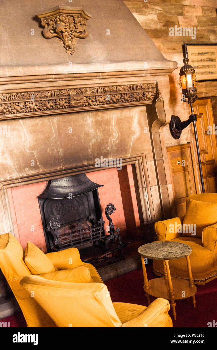 A great fireplace and some chairs in Bamburgh Castle, Northumberland, England, UK Stock Photo