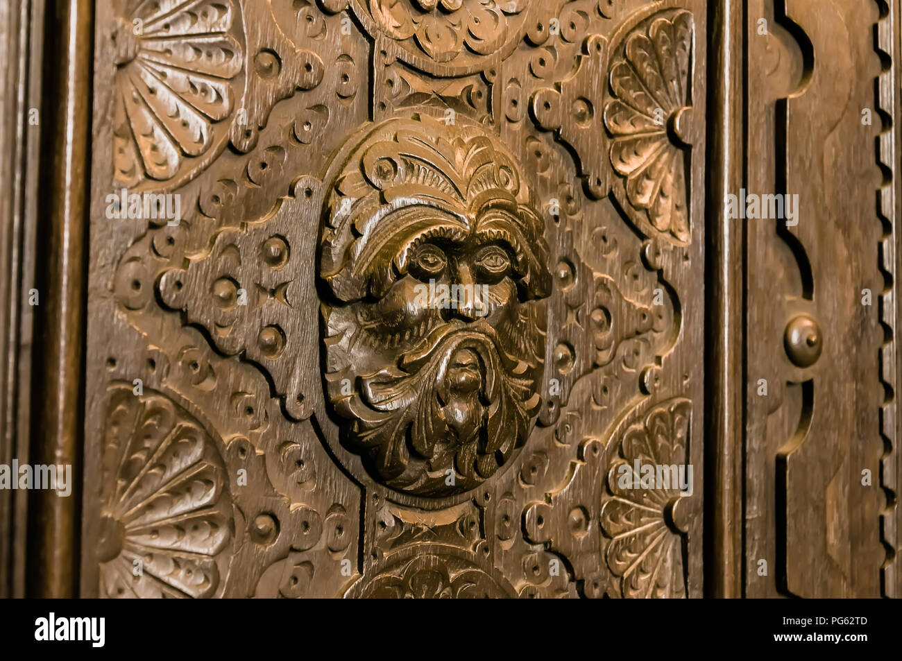 A depiction of a warrior or the green man, carved into a wooden cabinet in Bamburgh Castle, Northumberland, England, UK Stock Photo