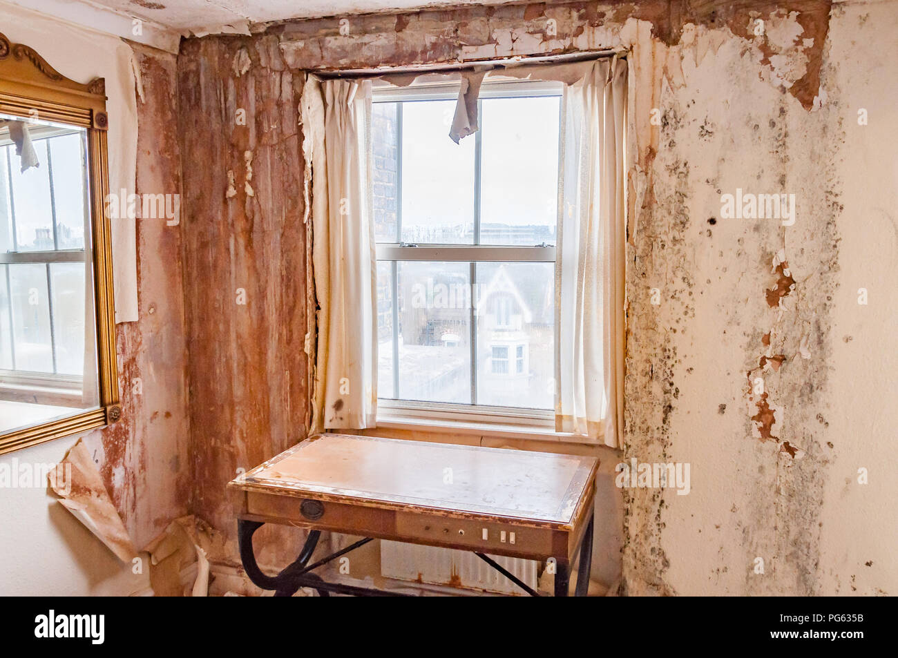 A dilapidated room with peeling paper and rotting walls in the Nayland Rock Hotel, Margate, England, UK Stock Photo