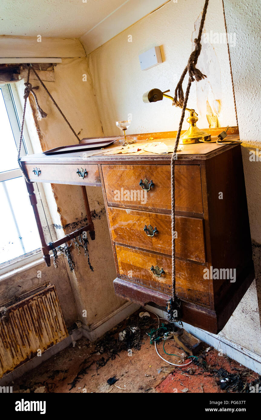 An art installation of a desk winched up to avoid high tide in a dilapidated room in the Nayland Rock Hotel, Margate, England, UK Stock Photo