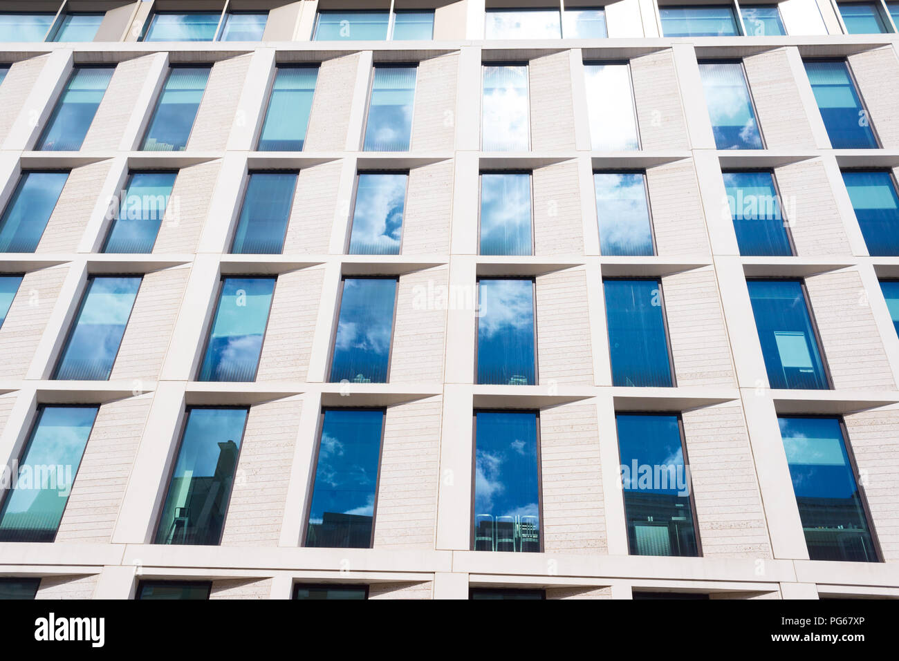 Facade of a modern style office building with multiple big glass windows Stock Photo
