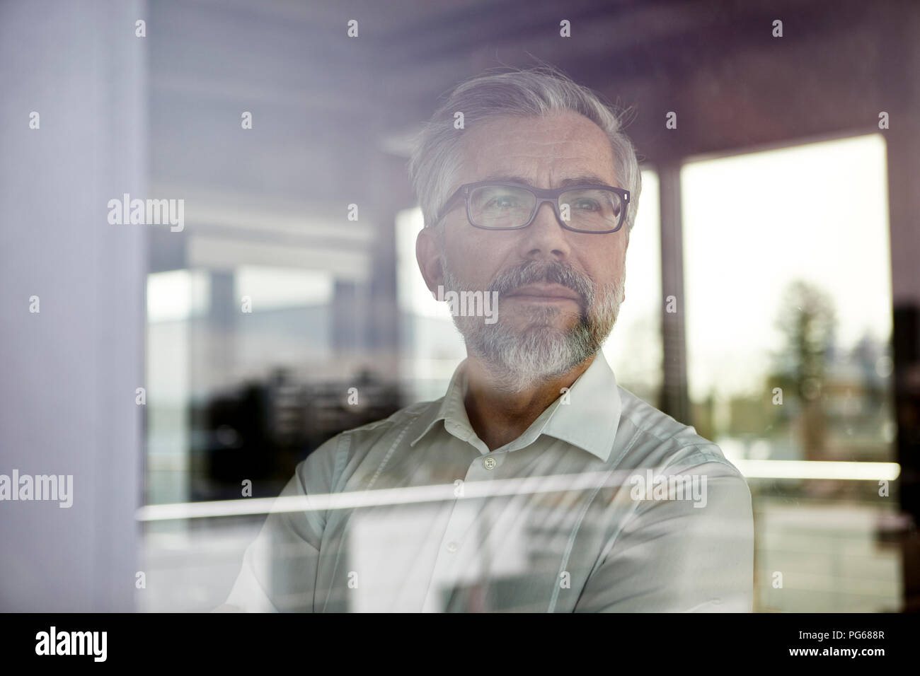 Portrait of businessman looking out of window Stock Photo