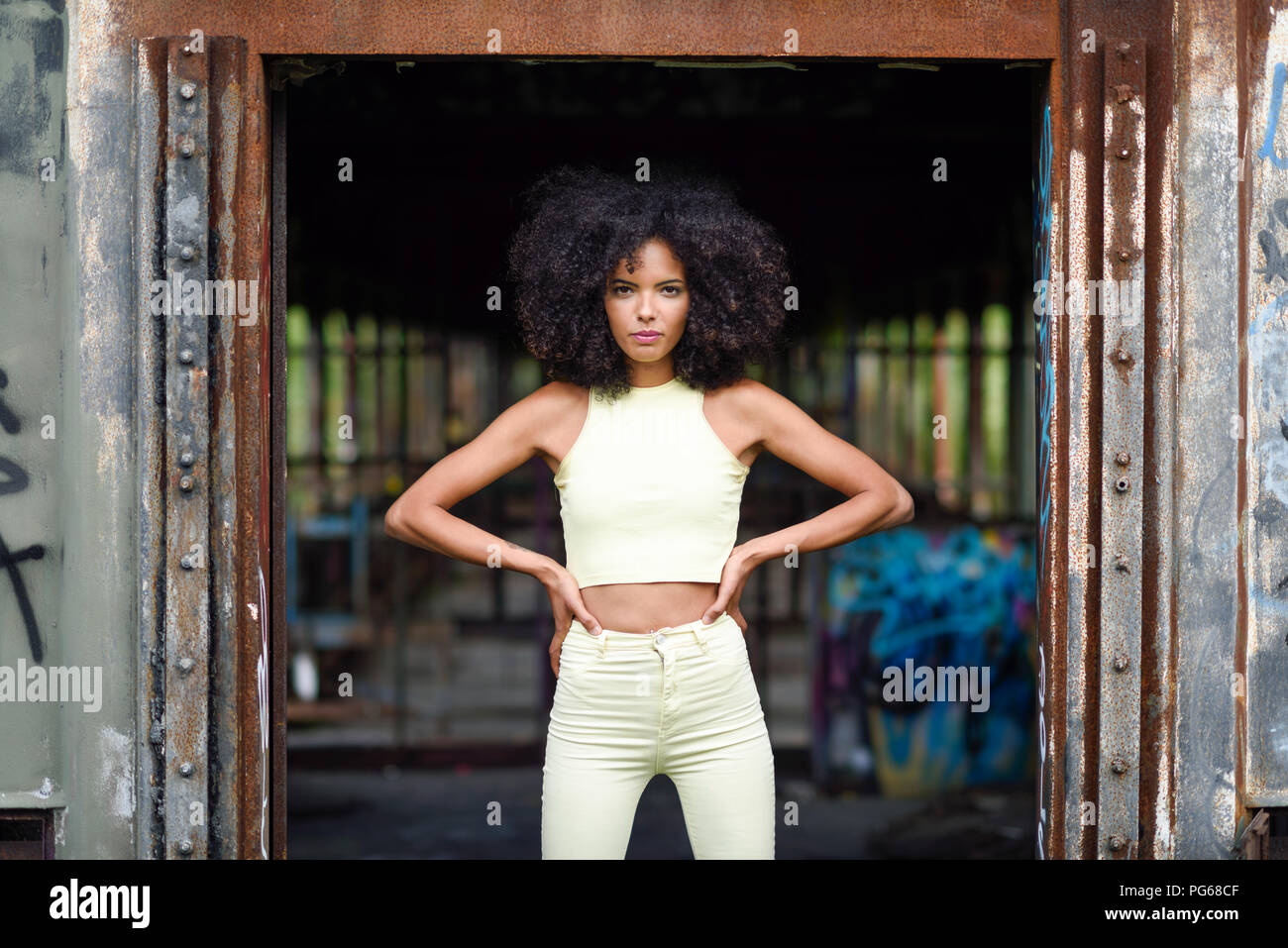 Portrait of fashionable young woman standing in abandoned and destroyed old train Stock Photo