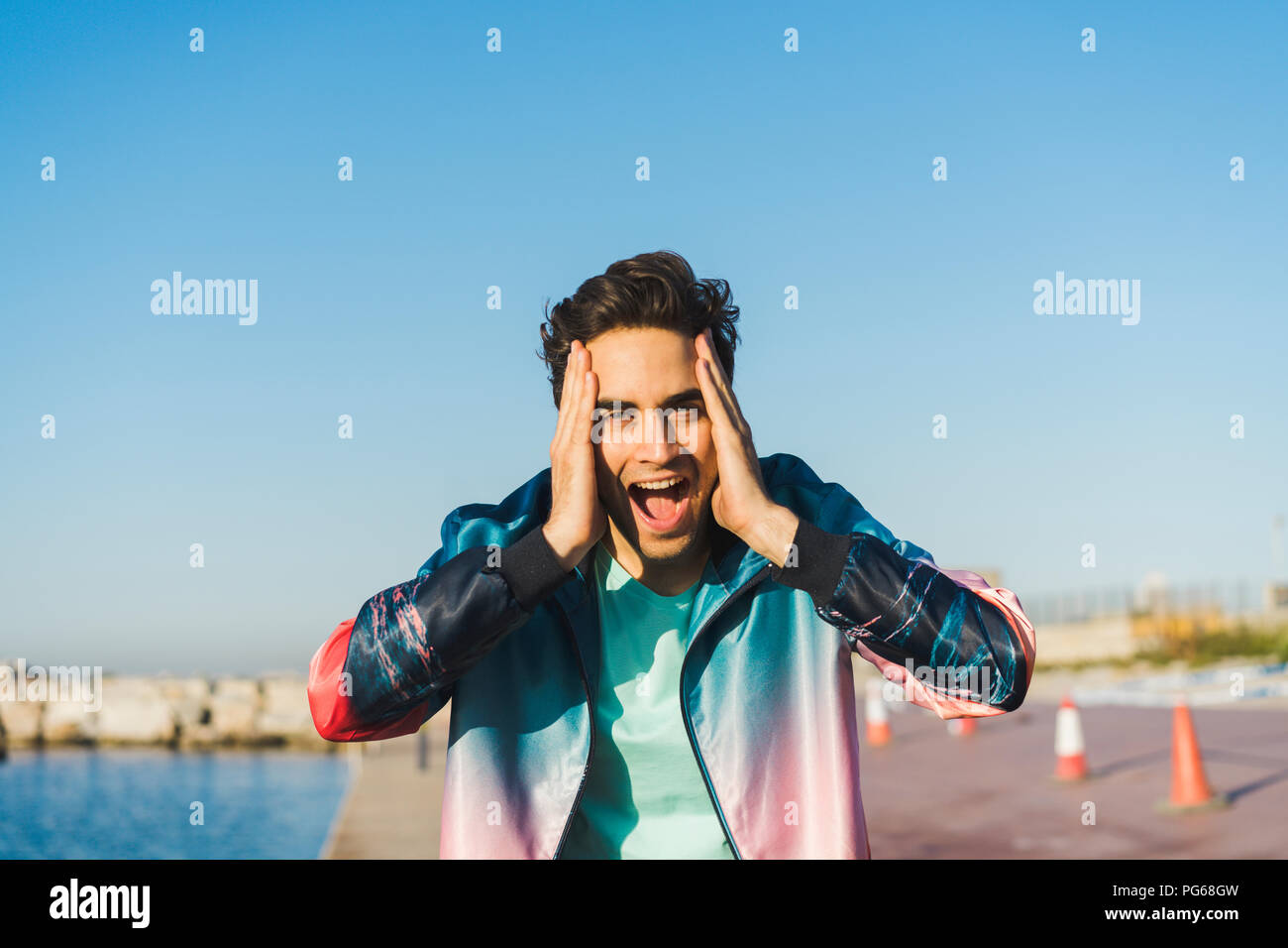 Surprised man screaming for joy with hands on head Stock Photo