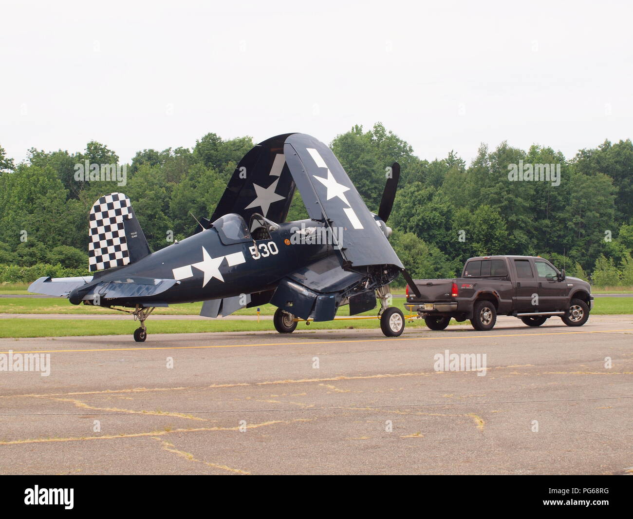 World War 2 Corsair warbird prepping for airshow at West Milford, NJ airport. The plane is being towed with folded wings. Stock Photo