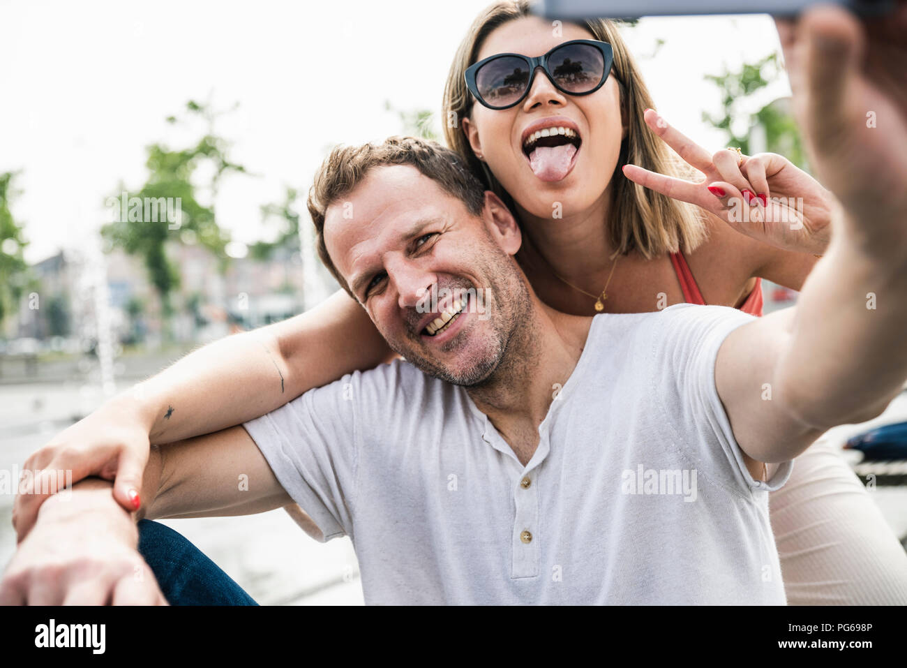 Happy couple taking a selfie outdoors Stock Photo