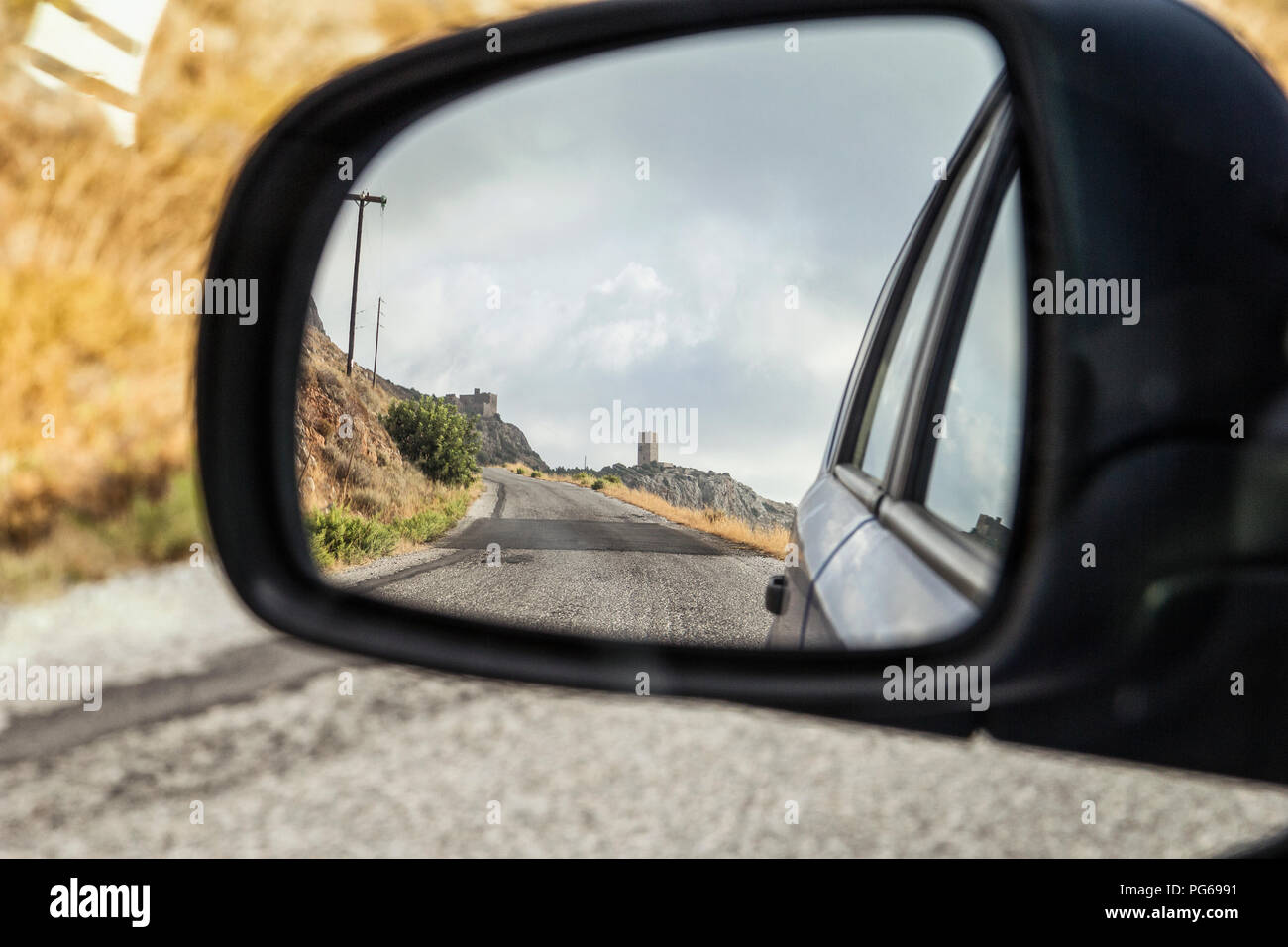 Greece, Peloponnese, village with typical tower house, mirrored in wing mirror Stock Photo