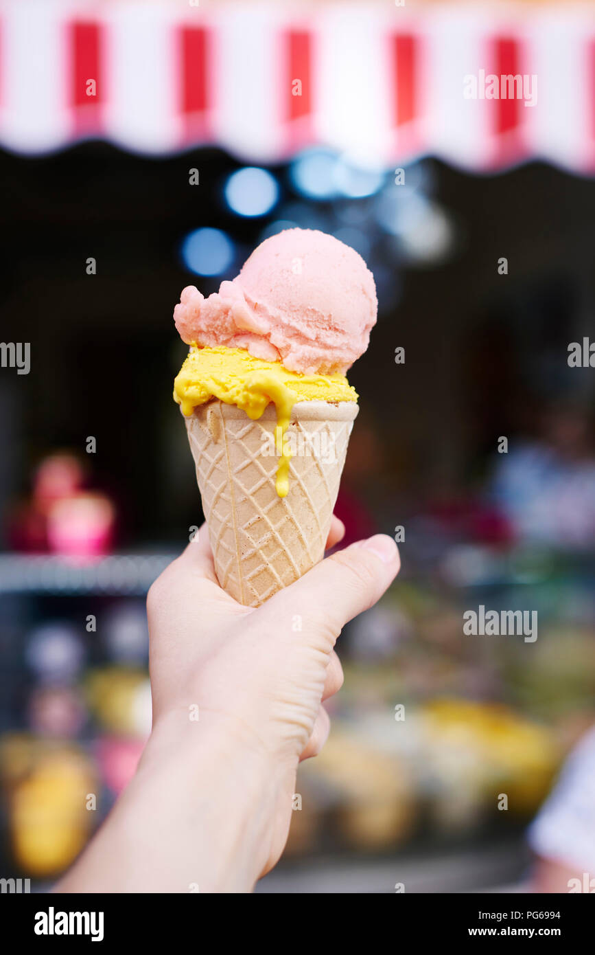 Woman's hand holding ice cream cone with two scoops Stock Photo