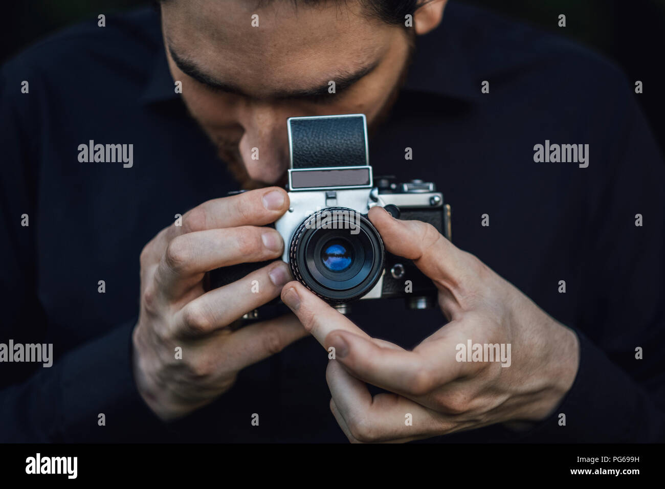 Young man photographing with analogue camera Stock Photo