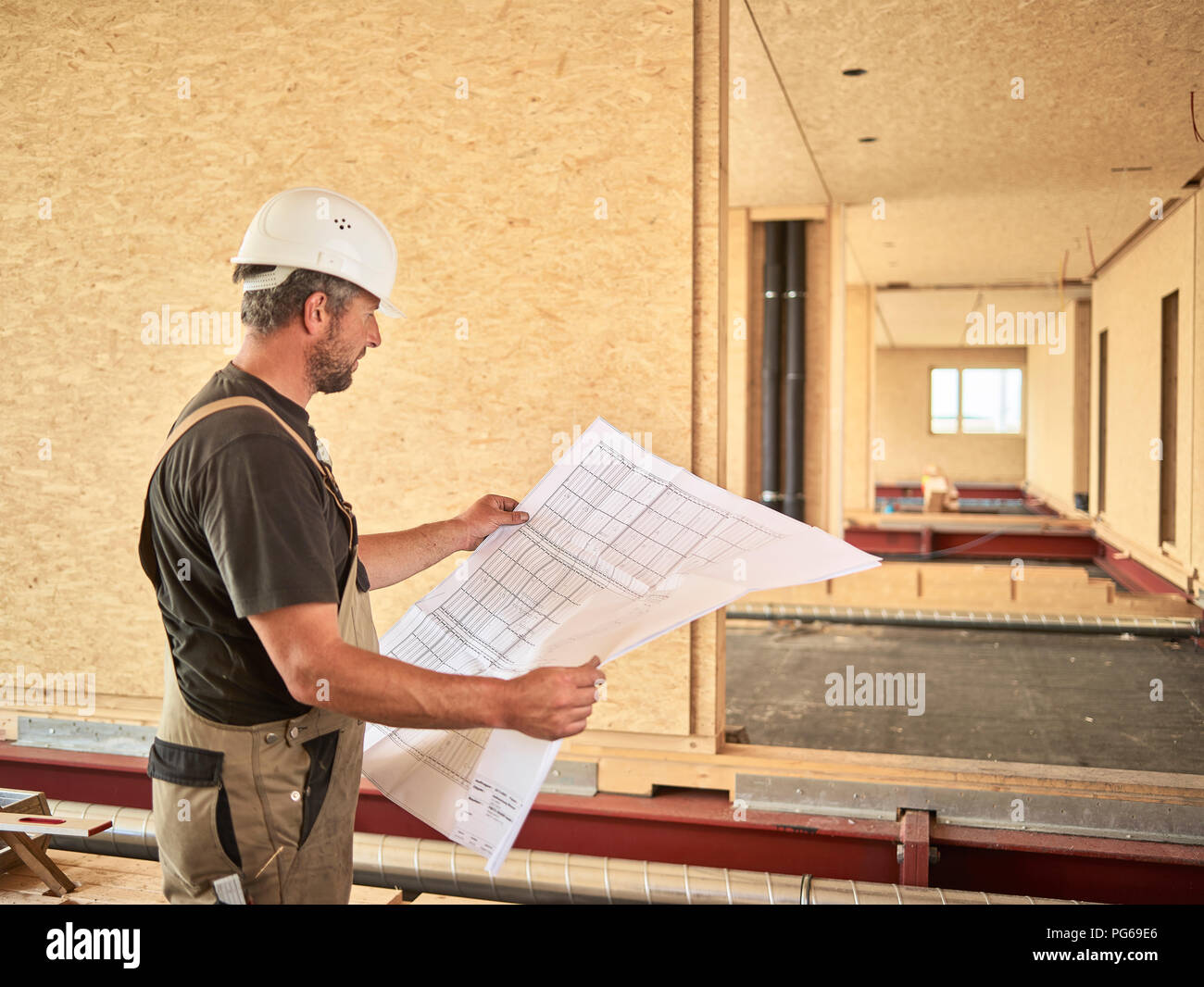 Worker with helmet holding construction plan Stock Photo