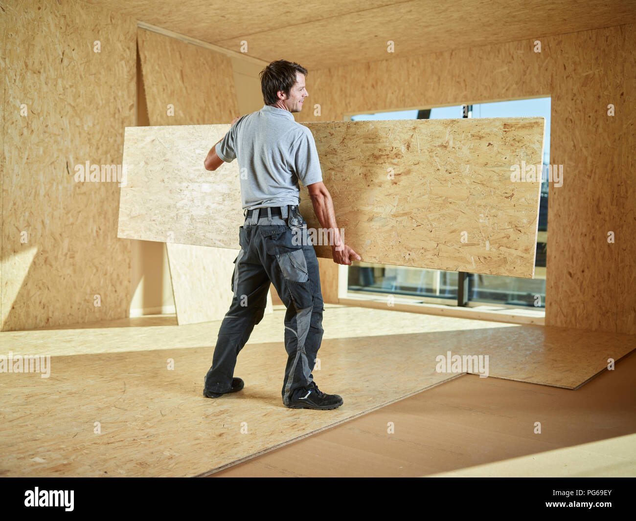Worker carrying flakeboard Stock Photo