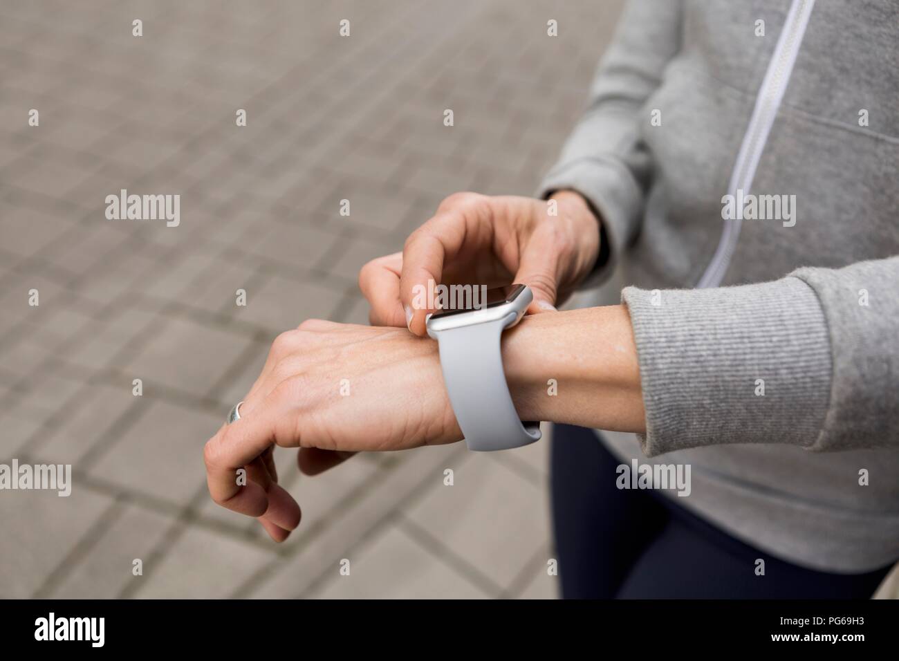Woman's hand adjusting settings of smartwatch, close-up Stock Photo