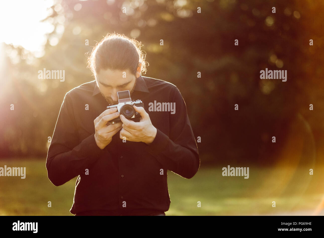 Young man photographing with analogue camera Stock Photo
