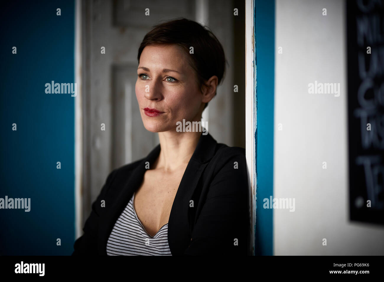 Portrait of a businesswoman leaning in door Stock Photo