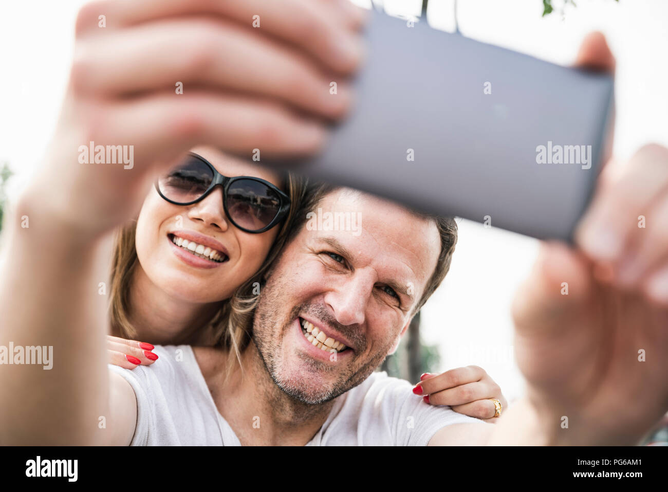 Happy couple taking a selfie outdoors Stock Photo