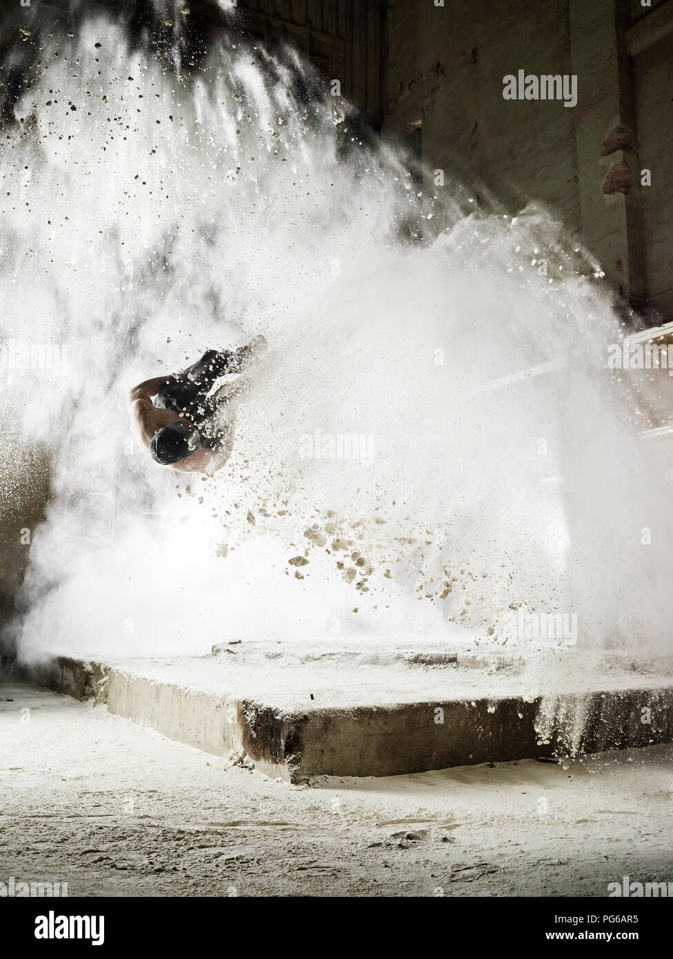 Man jumping in flour dust cloud during freerunning exercise Stock Photo