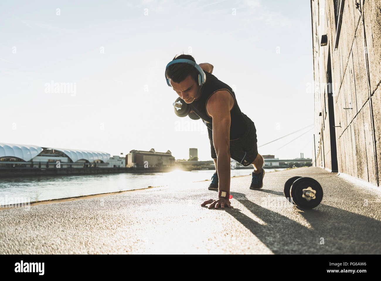 Fit athlete doing push ups at the river Stock Photo
