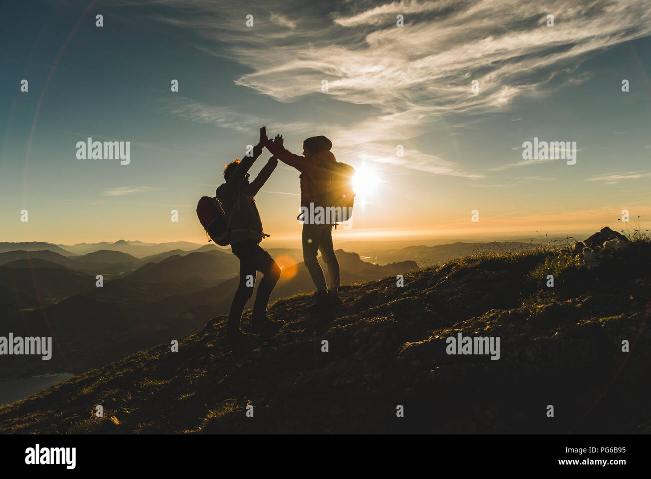 Austria, Salzkammergut, Cheering couple reaching mountain summit Stock Photo