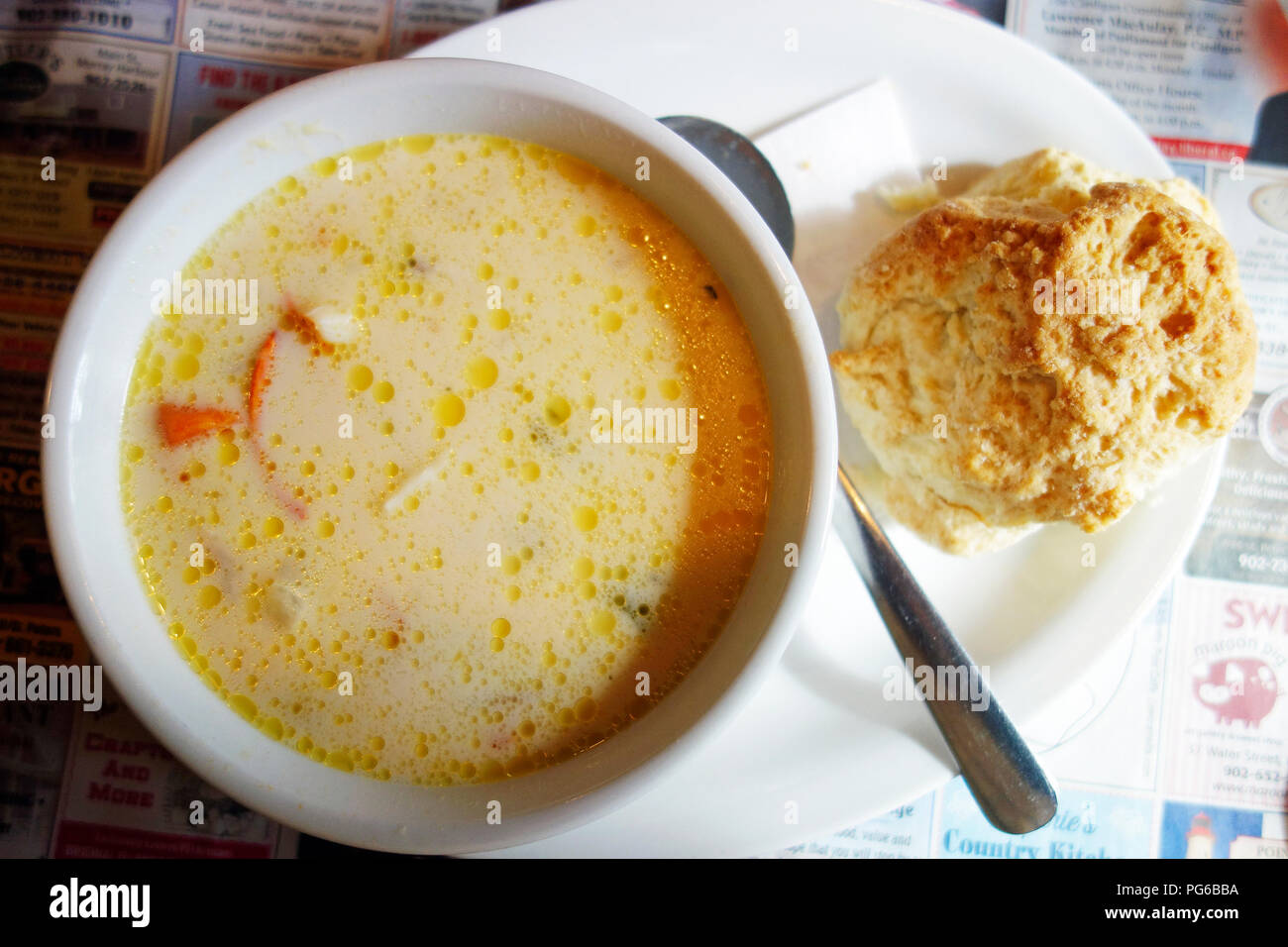 A bowl of seafood and lobster chowder and a biscuit in Prince Edward Island, Canada Stock Photo