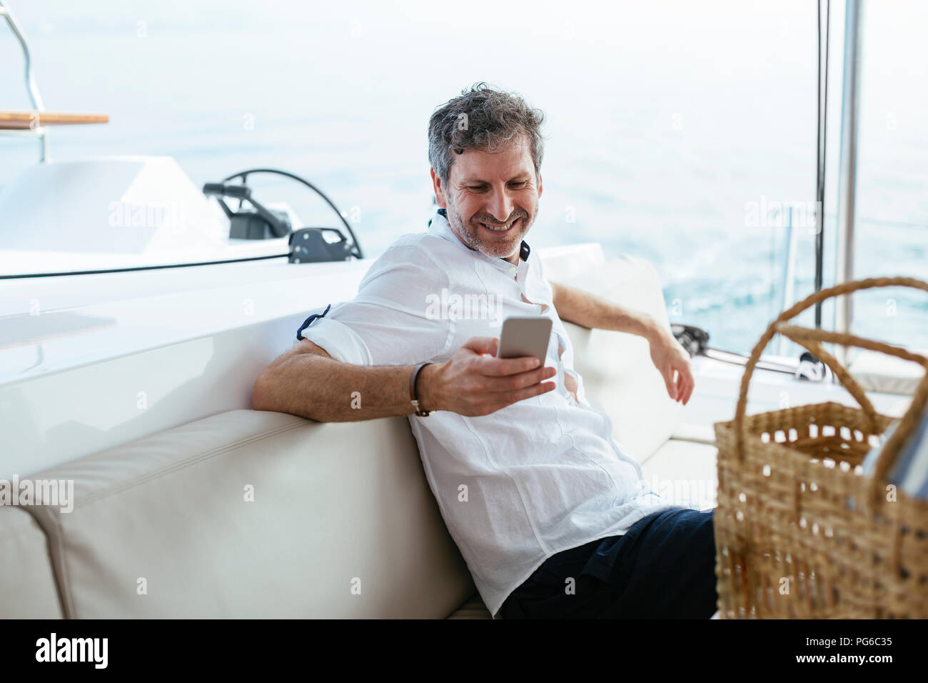 Mature man on a sailing trip having, using smartphone Stock Photo