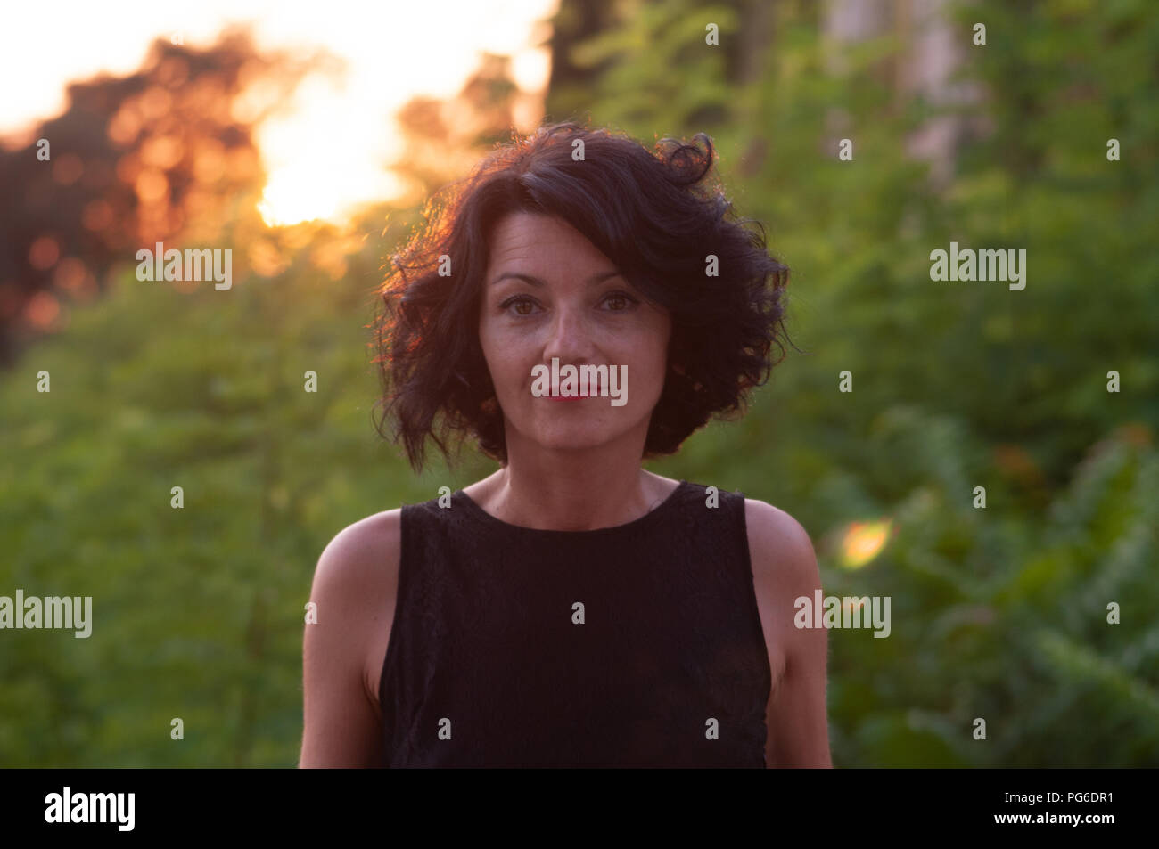 Half Length Portrait Of A Lady With A Black Dress And Short Wavy Dark Hair With An Intimate Expression With The Sun Behind You At Sunset Atmosphere Stock Photo Alamy Half Length Portrait Of A Lady With A Black Dress And Short Wavy Dark Hair With An Intimate Expression With The Sun Behind You At Sunset Atmosphere Stock Photo Alamy