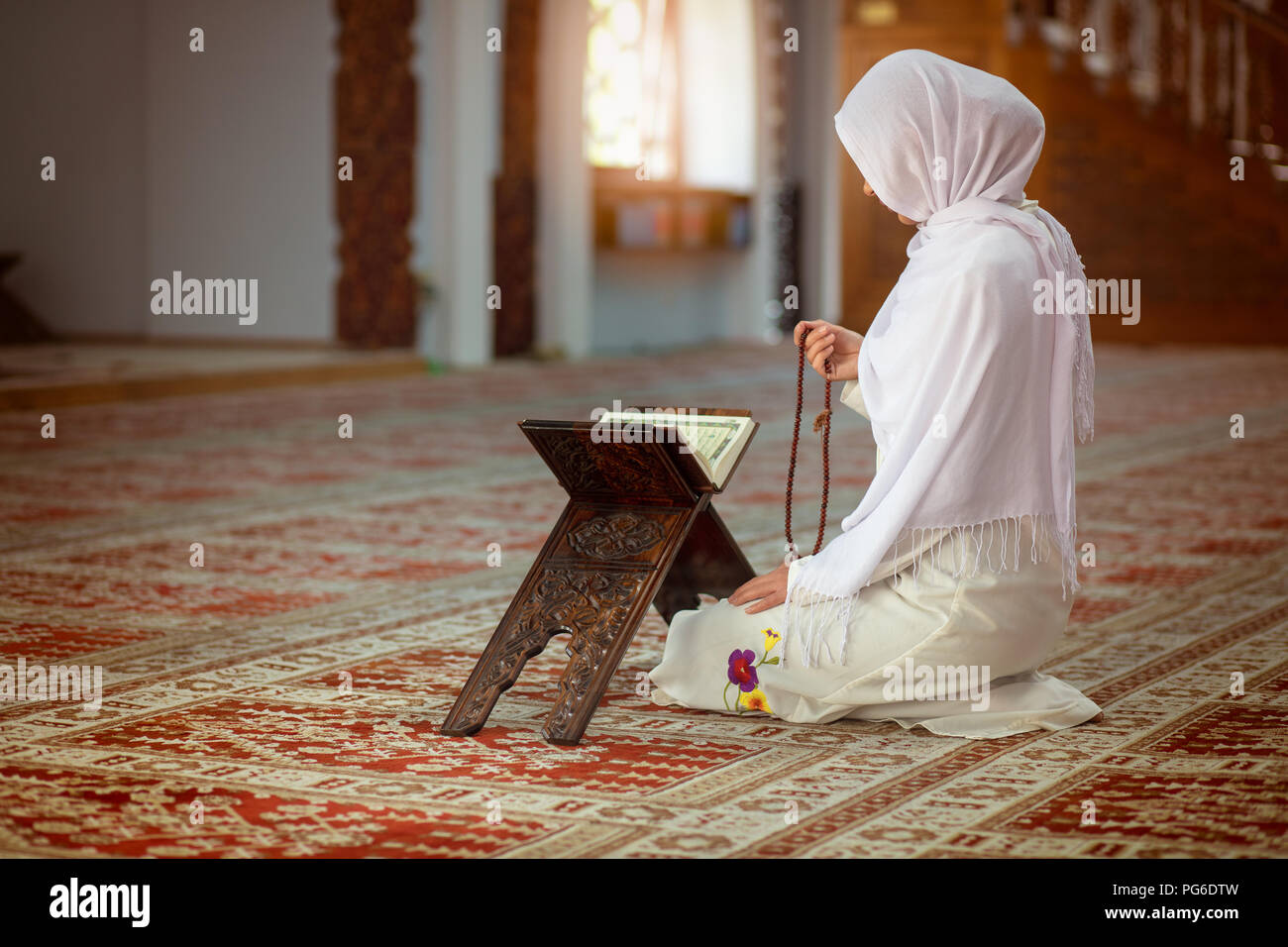 Young muslim woman praying in mosque with quran Stock Photo Alamy