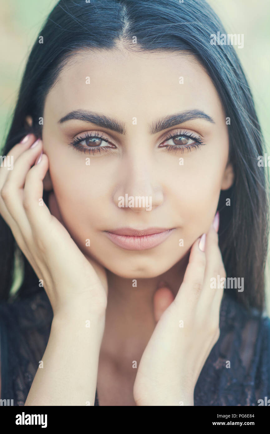 Beautiful young woman hands touching face outdoors Stock Photo - Alamy