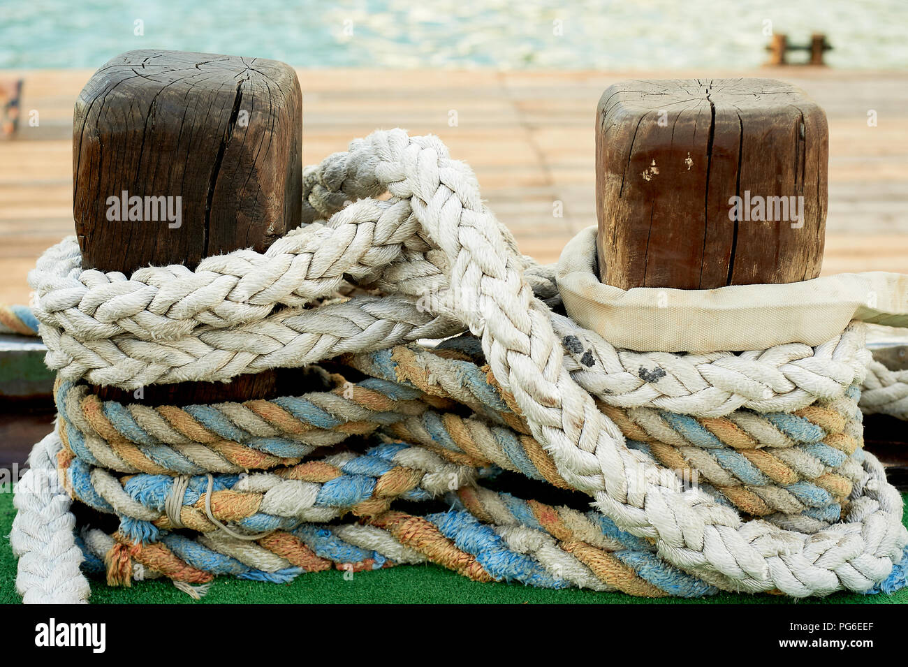 Rope wound on a wooden beam on the pier, prepared for mooring the ship