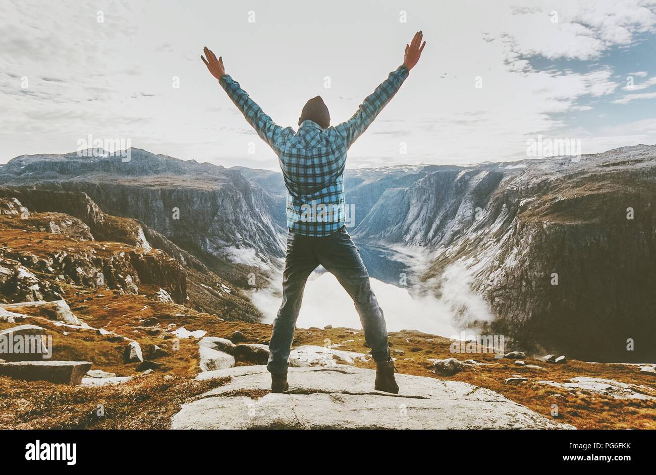 Traveler man exploring mountains alone happy raised hands adventure journey summer vacations traveling lifestyle weekend getaway Stock Photo