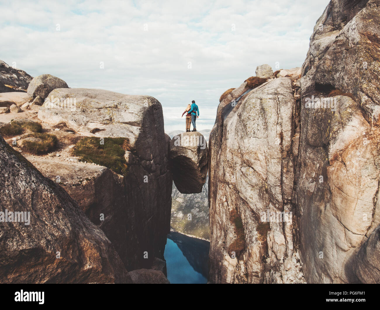 Travel couple on Kjeragbolten romantic trip in Norway Kjerag mountains vacations adventure lifestyle family man and woman together extreme journey Stock Photo
