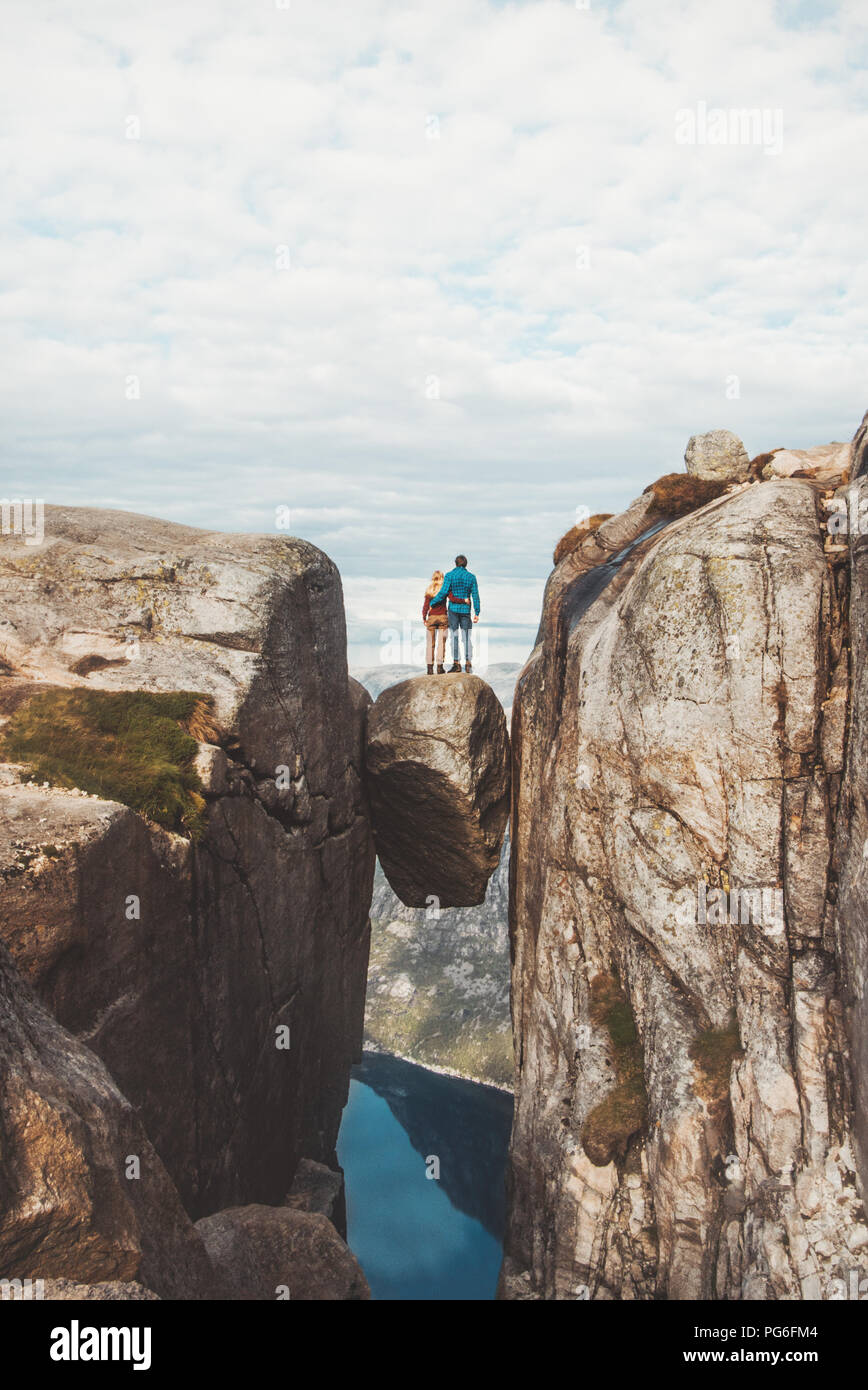 Couple standing hugging on Kjeragbolten Traveling in Kjerag mountains Norway vacations adventure lifestyle family man and woman together romantic jour Stock Photo