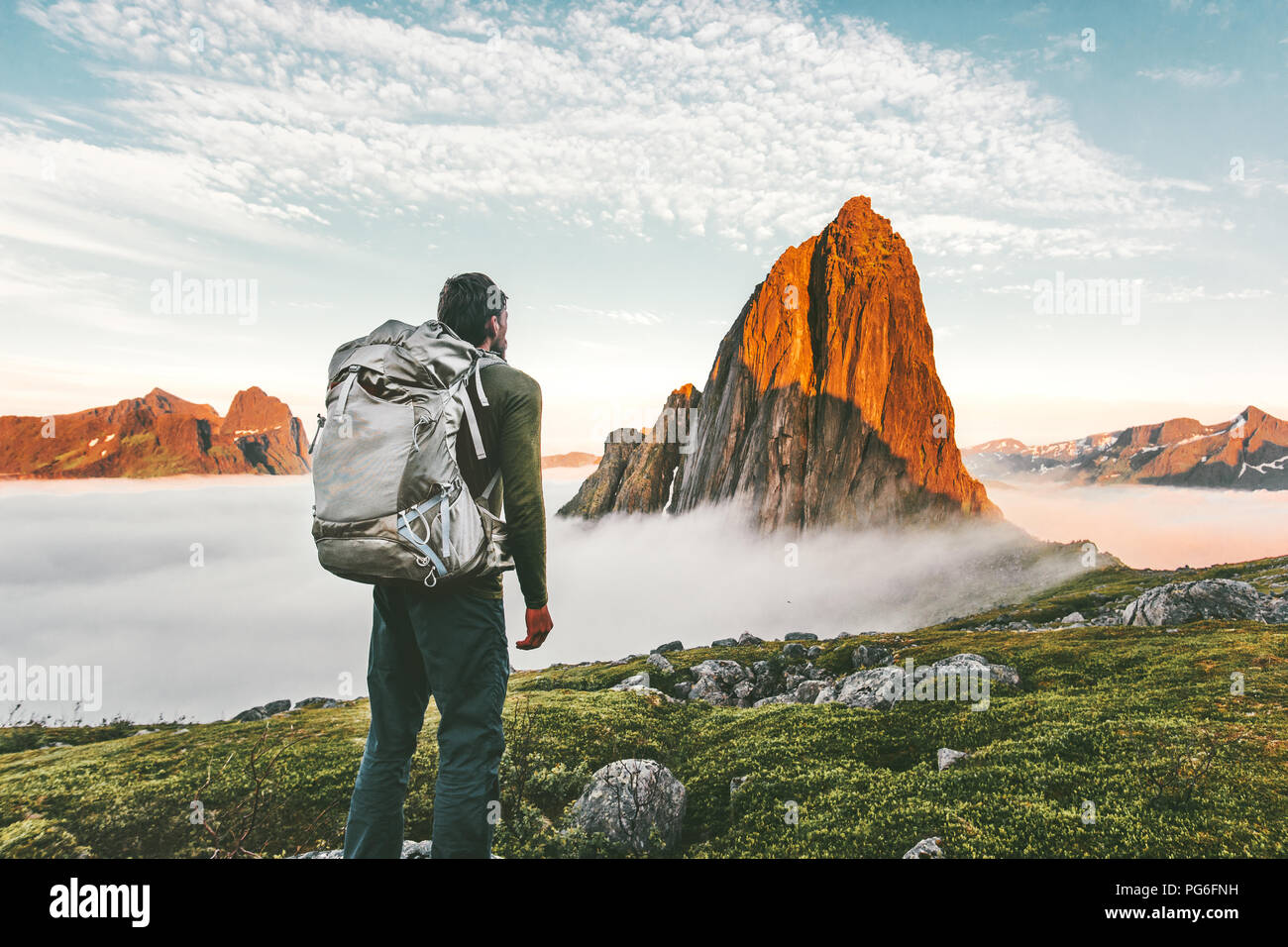 Backpacker man exploring sunset rocky mountains alone hiking
