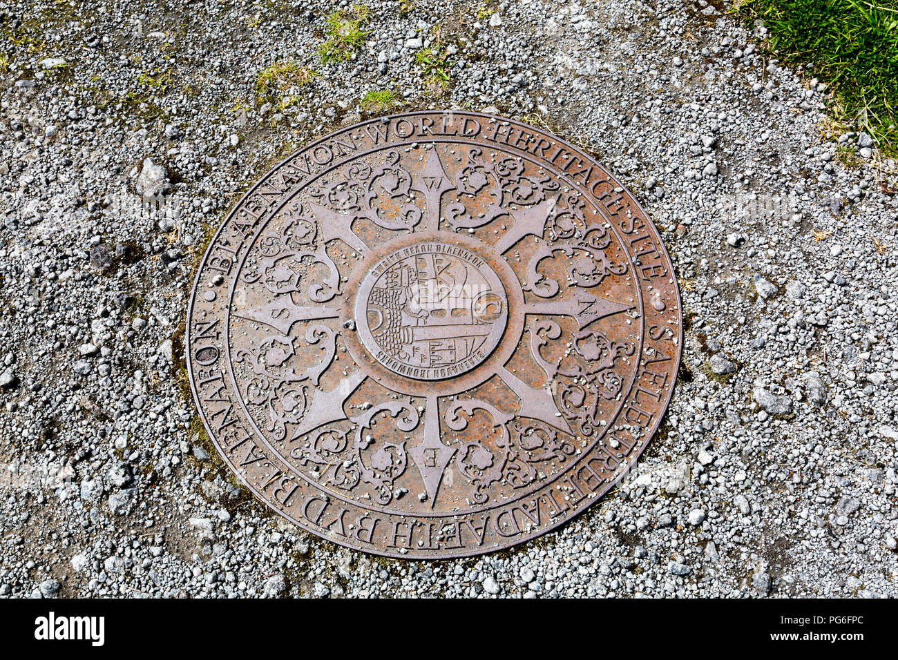 The metal plaque on the ground to commemorate that Blaenavon Ironworks is now a museum and UNESCO World Heritage Site in Blaenavon, Gwent, Wales, UK Stock Photo