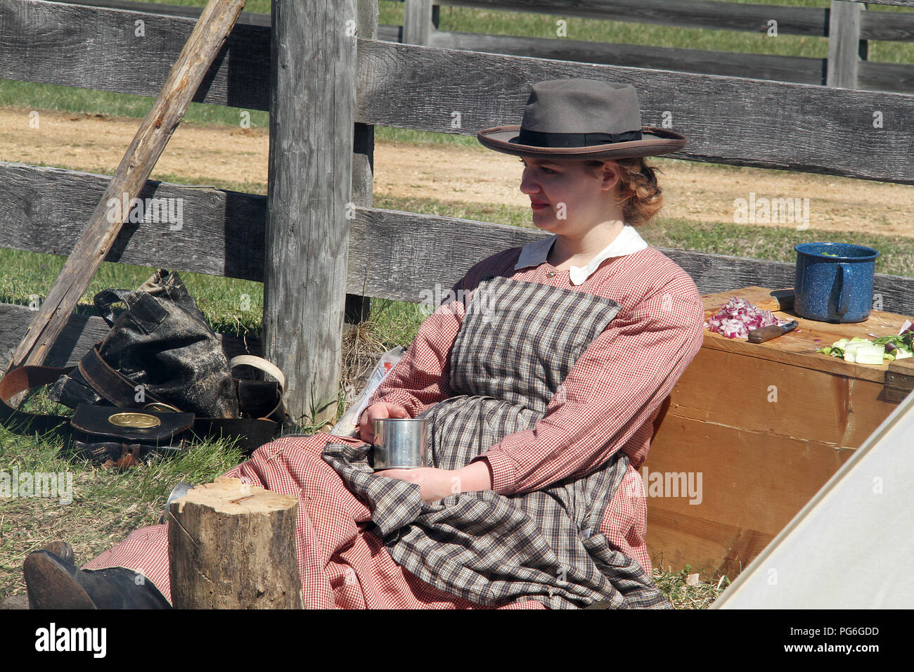 The Confederate Army camping during the American Civil War. Woman drinking from metal mug. Historical reenactment at Appomattox, Virginia. Stock Photo