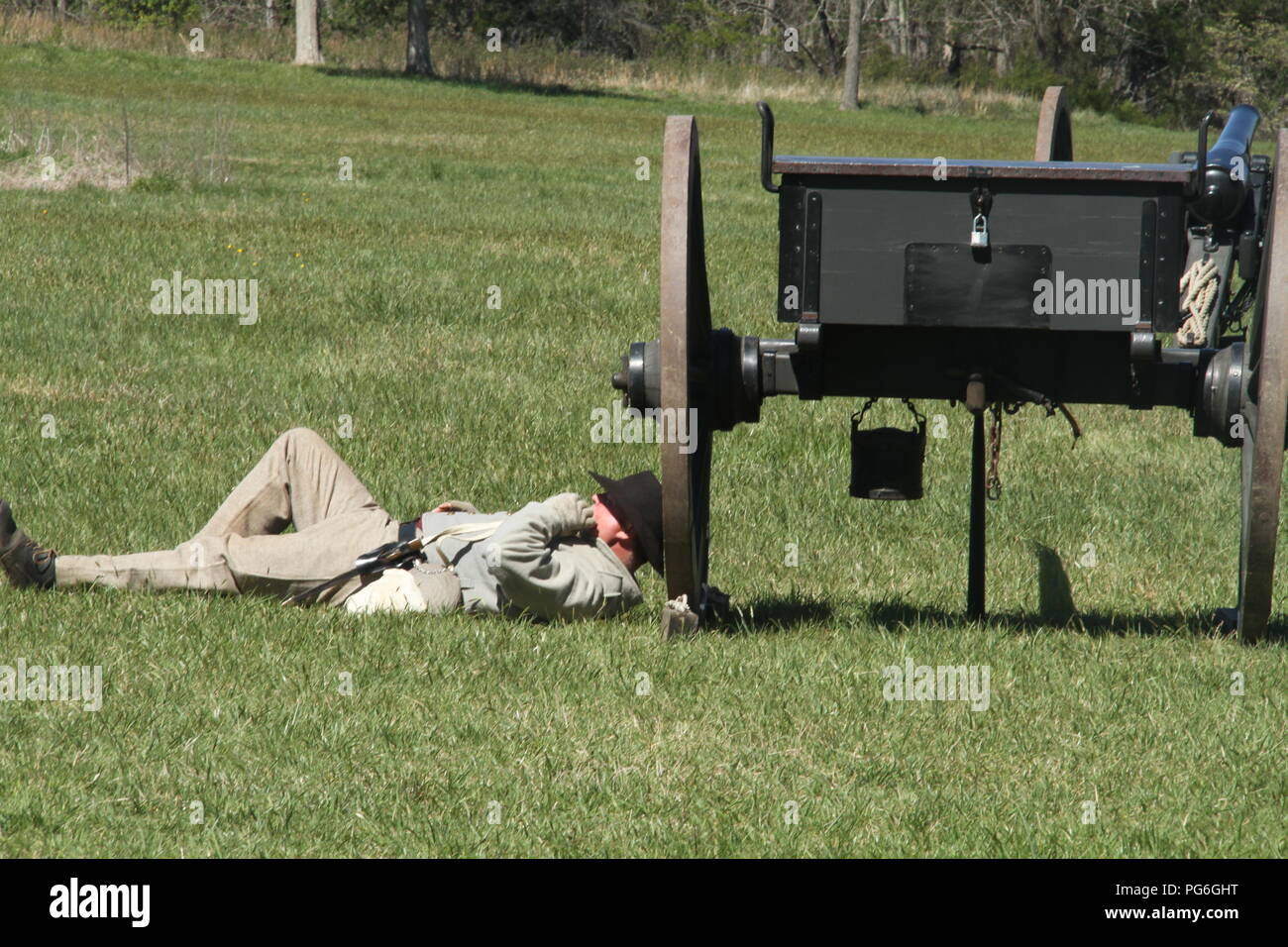 The Confederate Army during the American Civil War. Soldier resting behind a cannon. Historical reenactment at Appomattox, VA, USA. Stock Photo