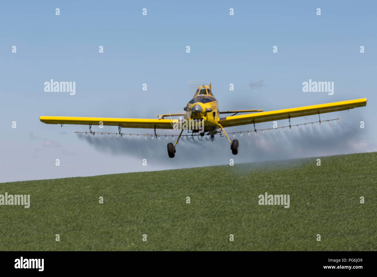Crop duster plane flying and spraying over crops in the Palouse region