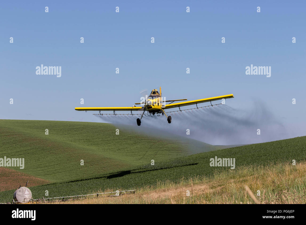 Crop duster plane flying and spraying over crops in the Palouse region