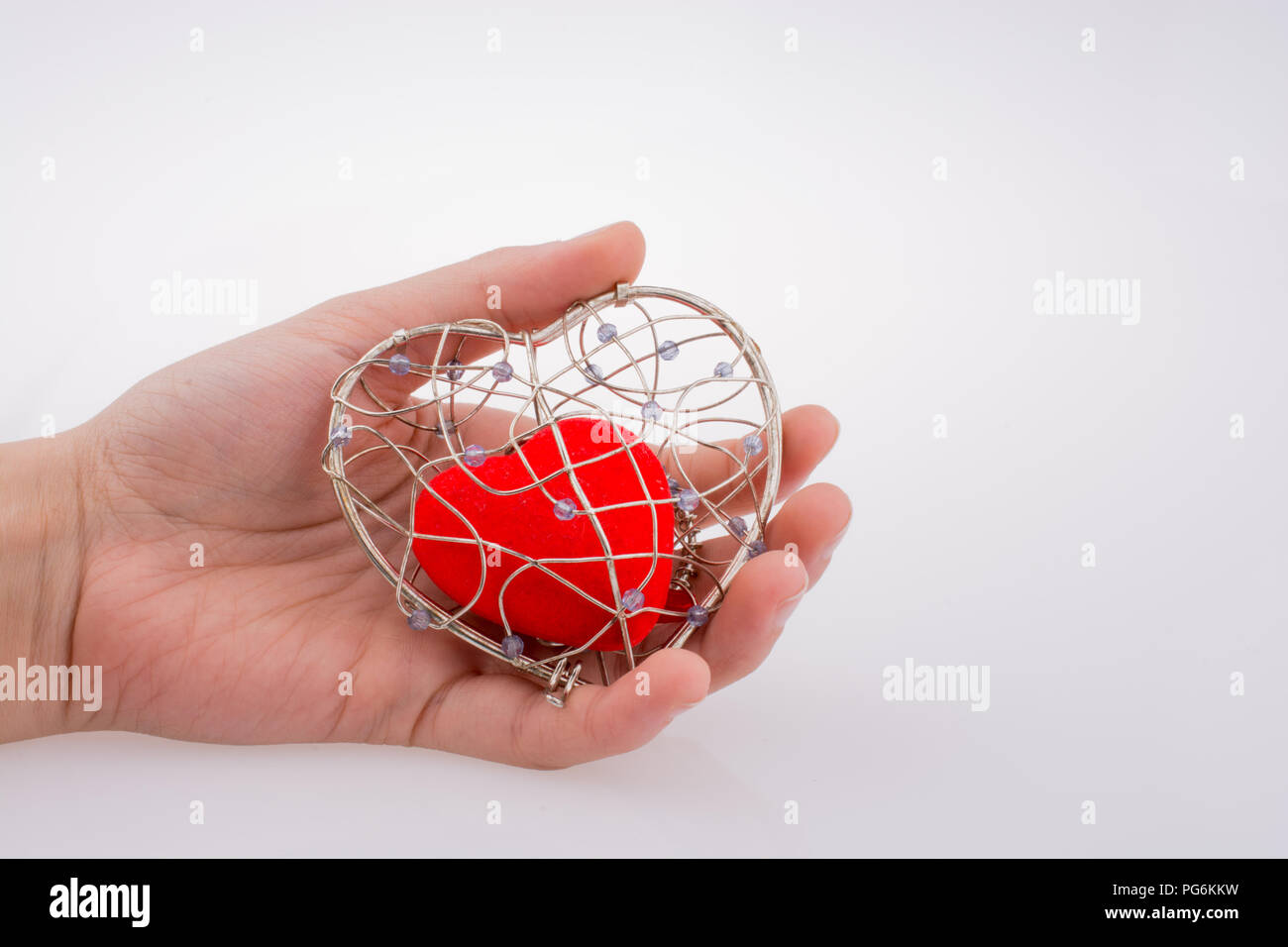 Red heart in a heart shaped cage Stock Photo Alamy